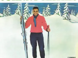 Person in red jacket holding skis in snow