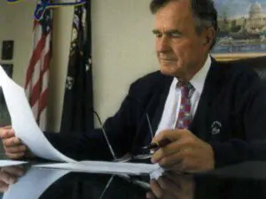 Man in suit reading documents at desk