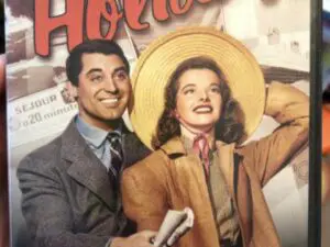 Vintage movie poster: smiling couple, woman with hat