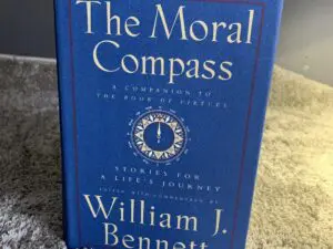 Blue book titled The Moral Compass