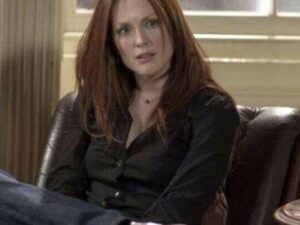 Red-haired woman seated in leather armchair