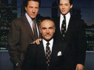 Three men in suits posing at desk