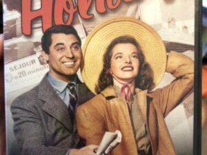 Vintage movie poster: smiling couple, woman with hat