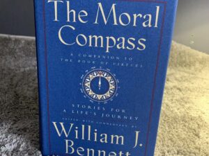 Blue book titled The Moral Compass