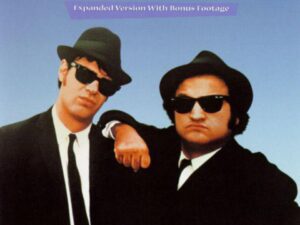 Two men in black suits and sunglasses